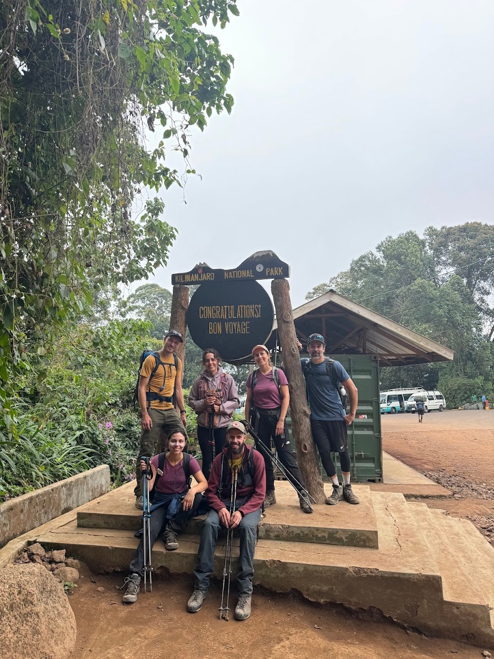 Group photo at the Mweka Gate, which reads "Congratulations! Bon Voyage"