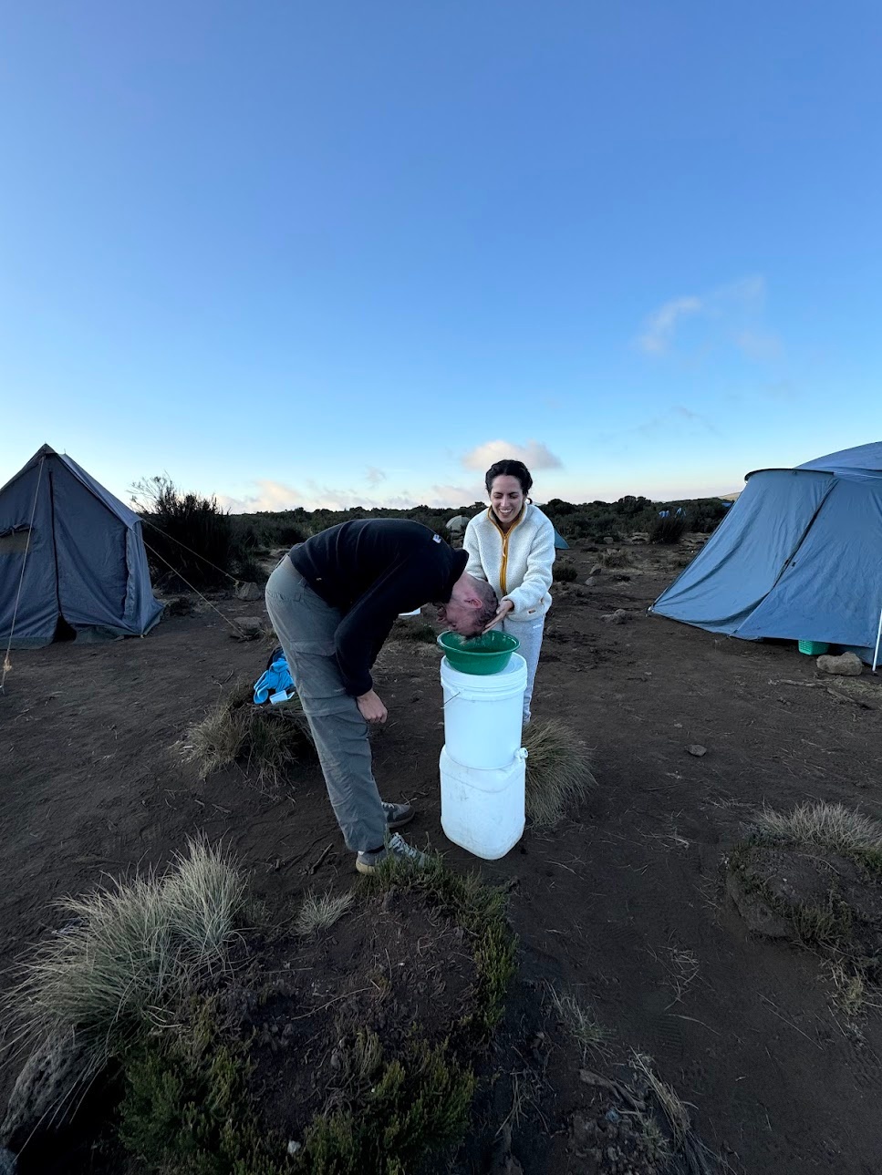 Claus washing hair in the camp using a water bowl