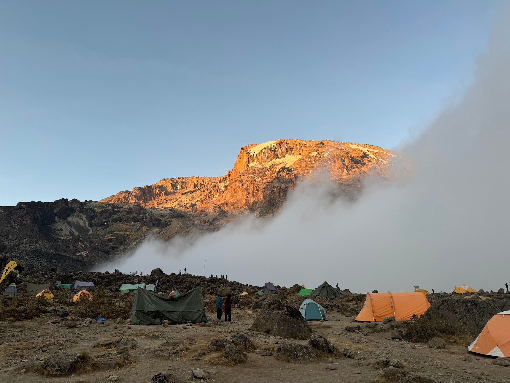 Barranco wall illuminated by the sunset light, with the campsite in the valley below