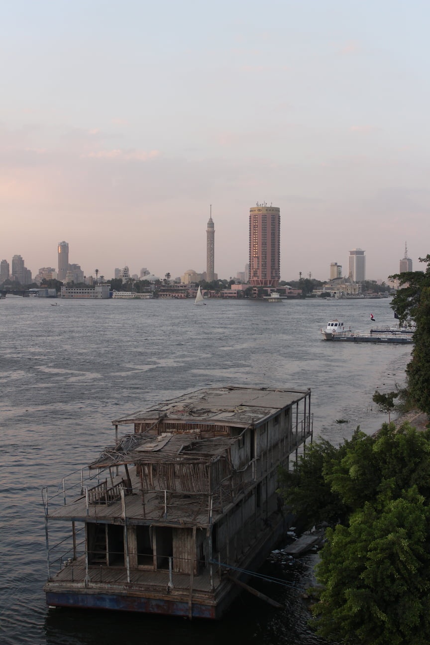 Nile river, Cairo. An abandoned boat contrasts with the modern skyscrapers in the background.