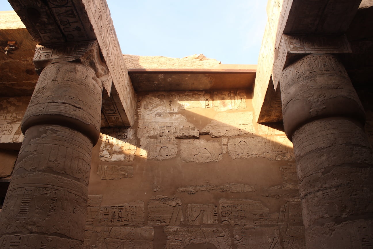 Details of a wall and two columns, decorated with hieroglyphs and other figures, in the Karnak Temple