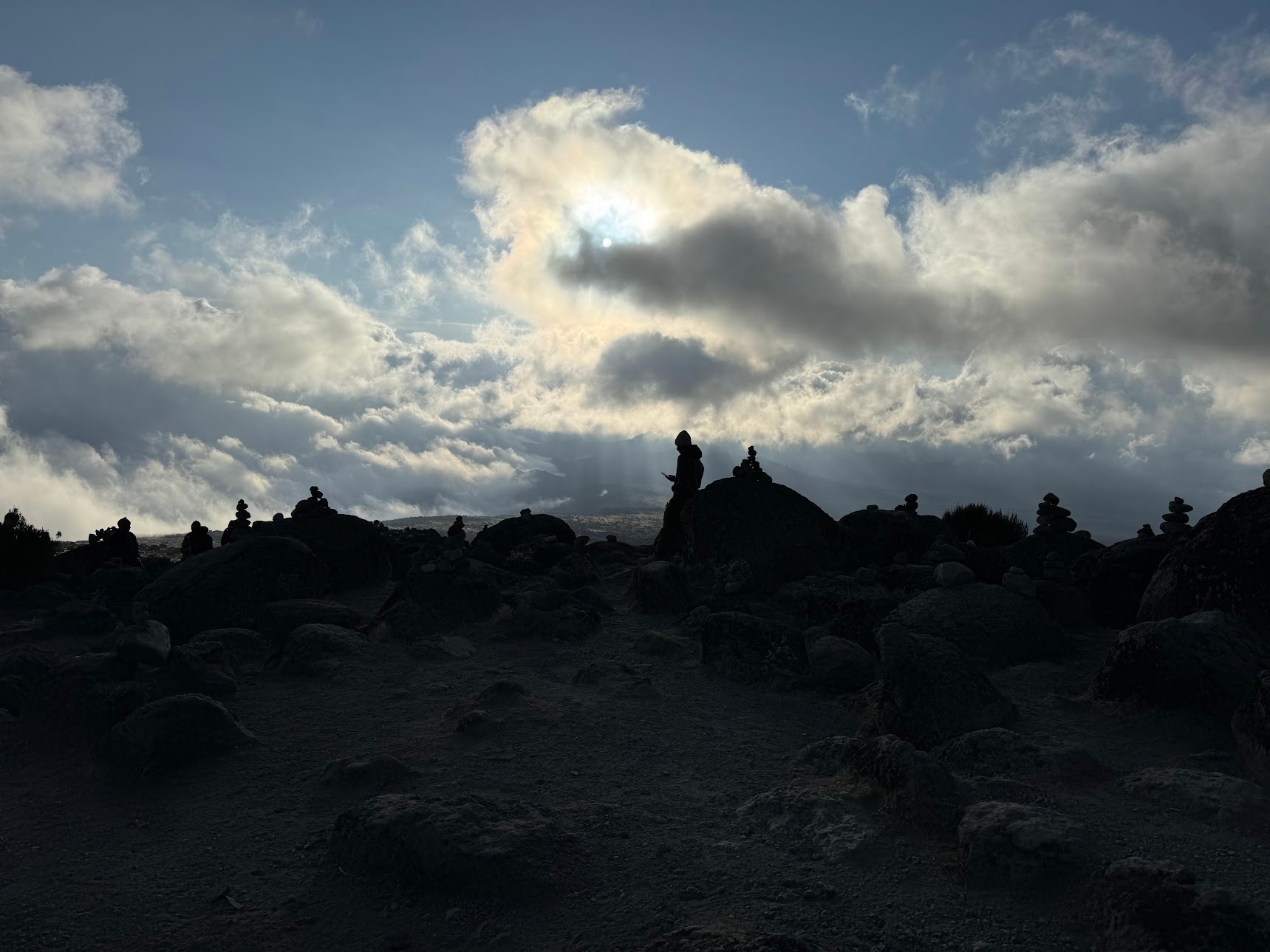 The silhouette of multiple cairns against the sunset light